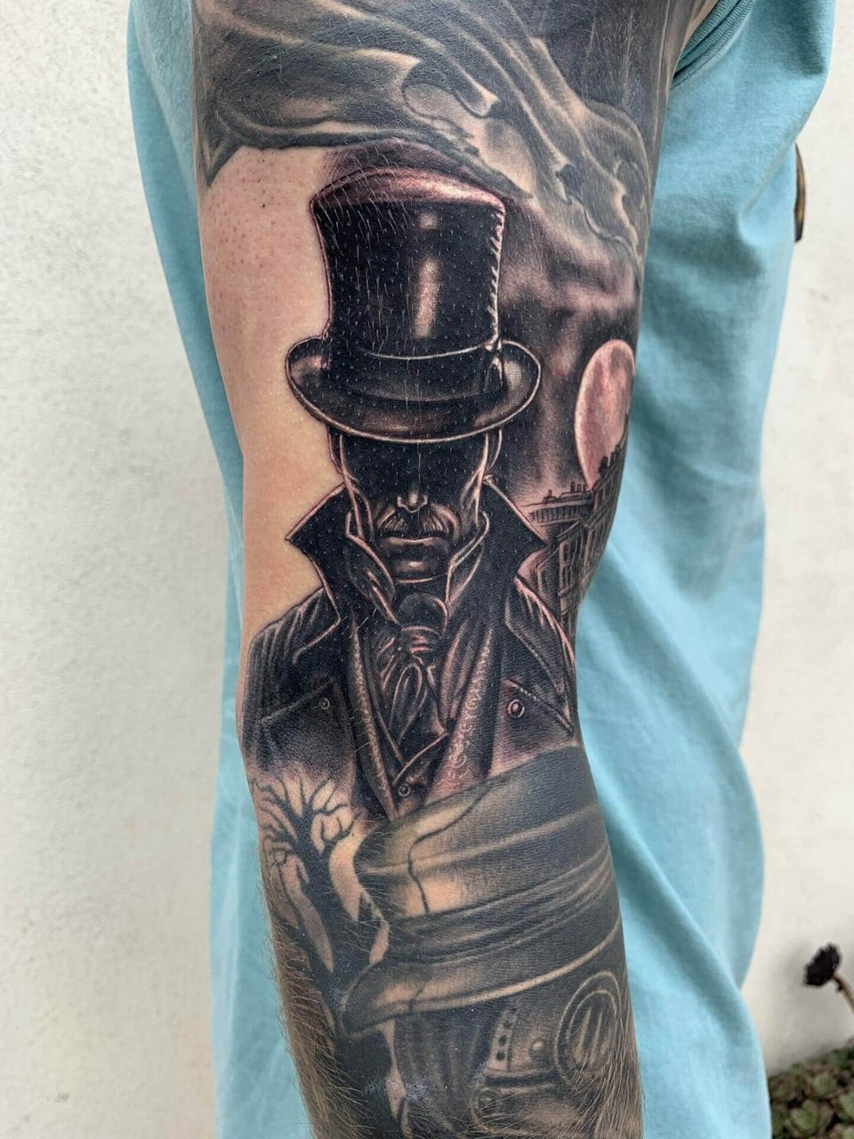 A black and grey realism man in a top hat stands above a moonlit street on an arm.