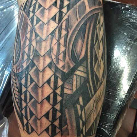 Polynesian geometric pattern wrapping a calf, tattooed by Seth Reynolds