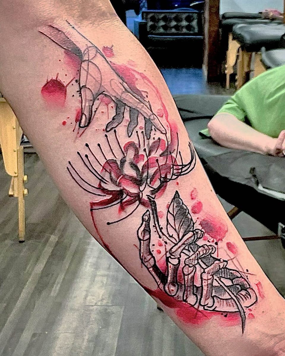 An outlined hand and a skeletal hand frame a red spider lily with watercolor splashes on the forearm.