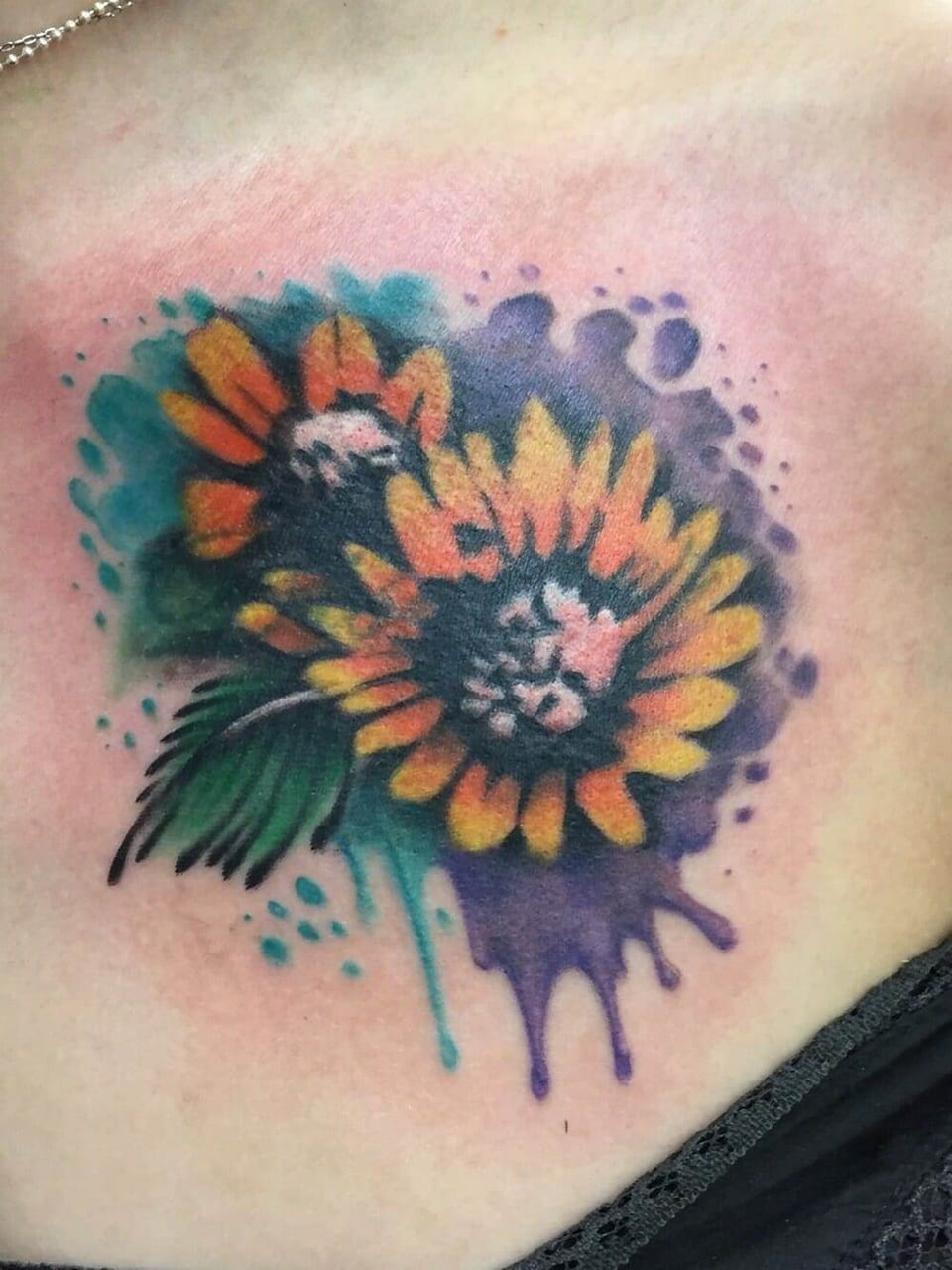 Watercolor yellow sunflowers sit over teal and purple splashes on the upper chest.