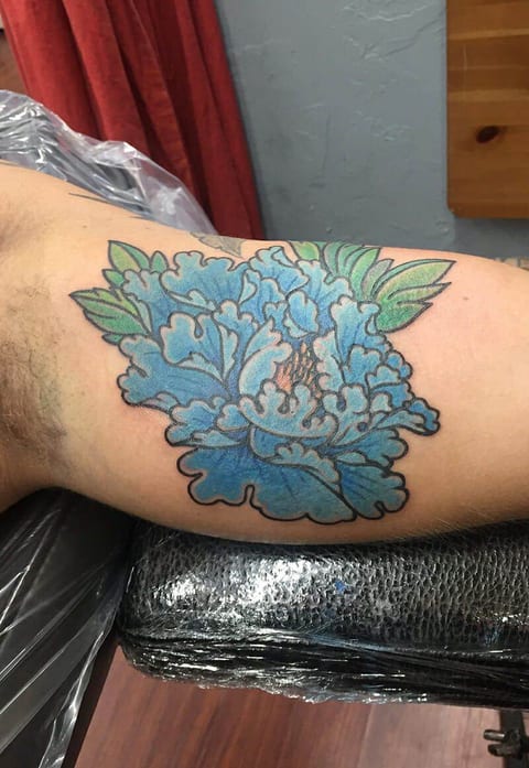 A Japanese blue peony with green leaves fills the inner upper arm.
