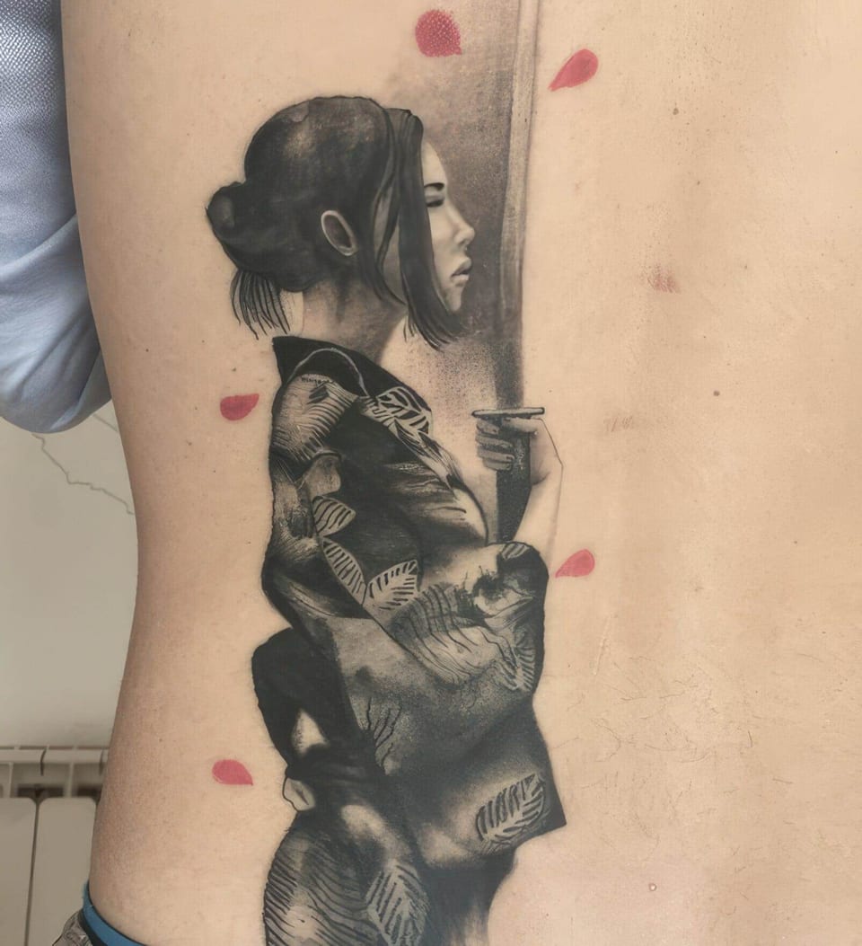 A black and grey woman in a kimono holds a sword amid red petals on the back.