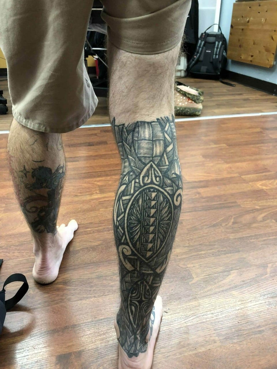 Polynesian turtle-shell and pattern leg sleeve seen from behind on a standing man, tattooed by Seth Reynolds