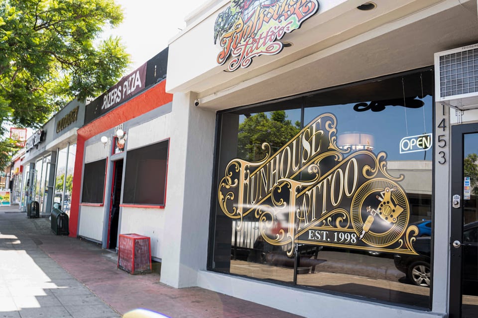 Funhouse Tattoo storefront from the left, with window lettering reading EST. 1998, an Open sign and the number 1453.