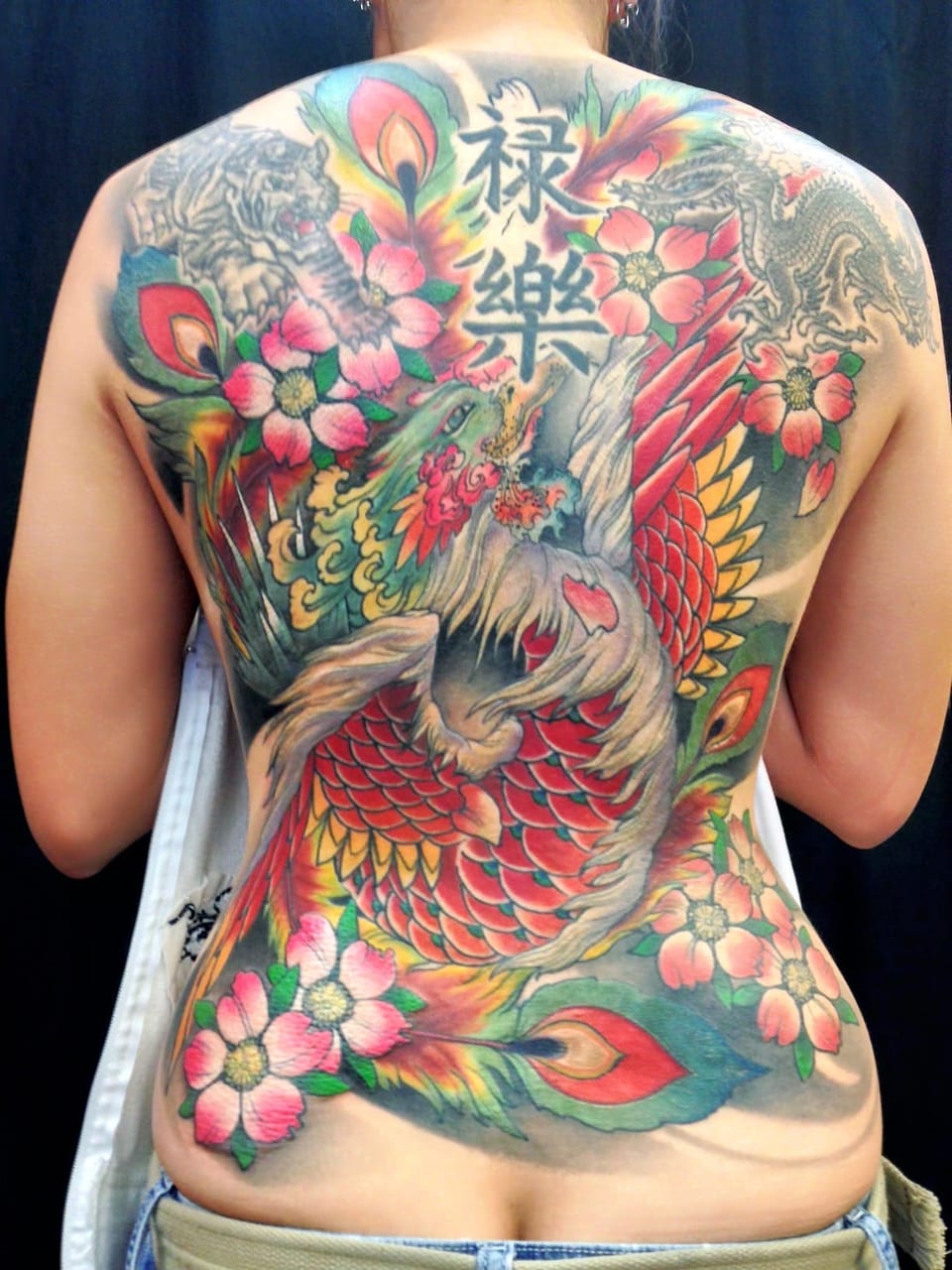 A color Japanese phoenix, blossoms, tiger and dragon cover a back.
