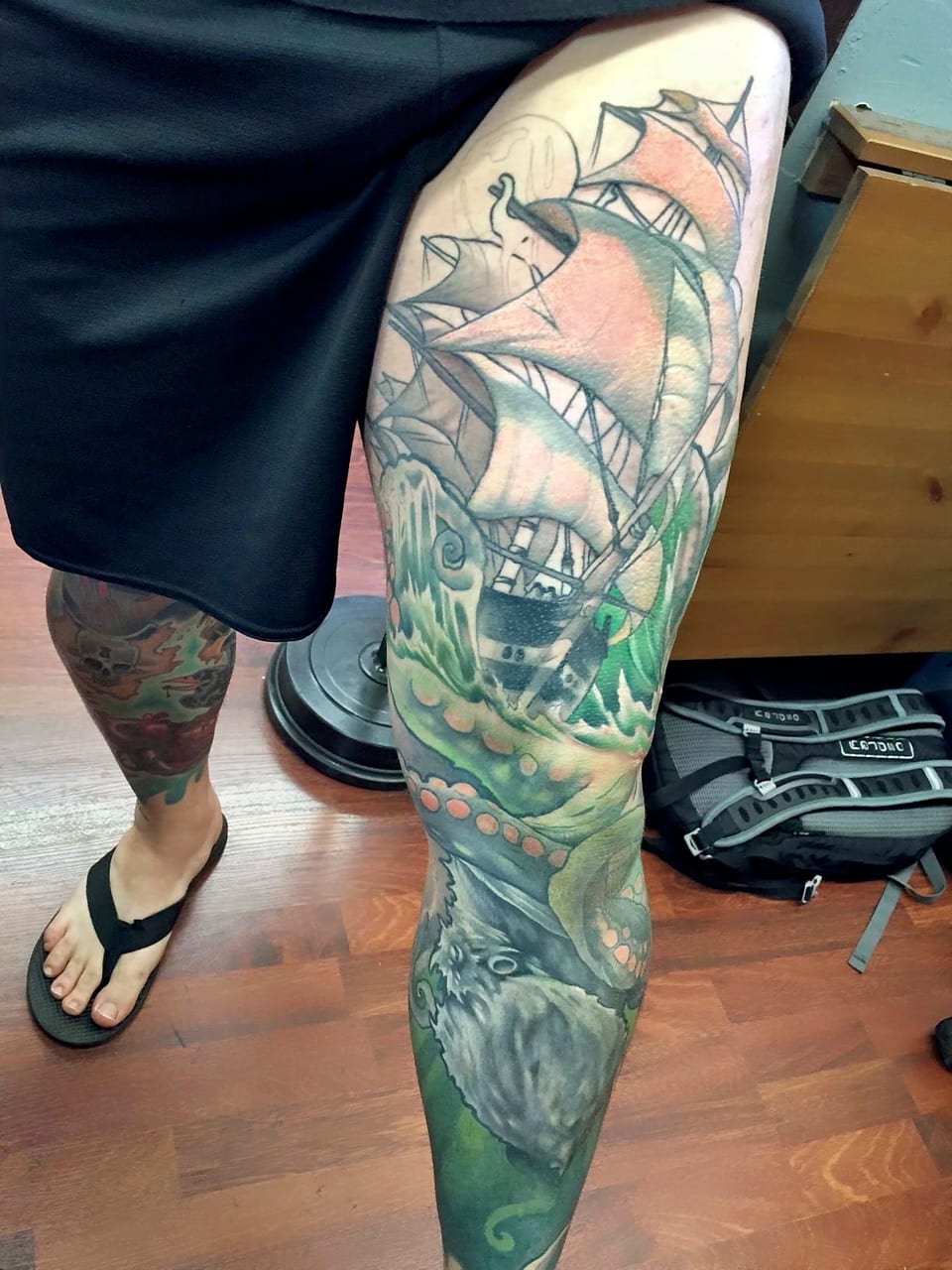 A color illustrative sailing ship, waves and tentacles form a leg sleeve.