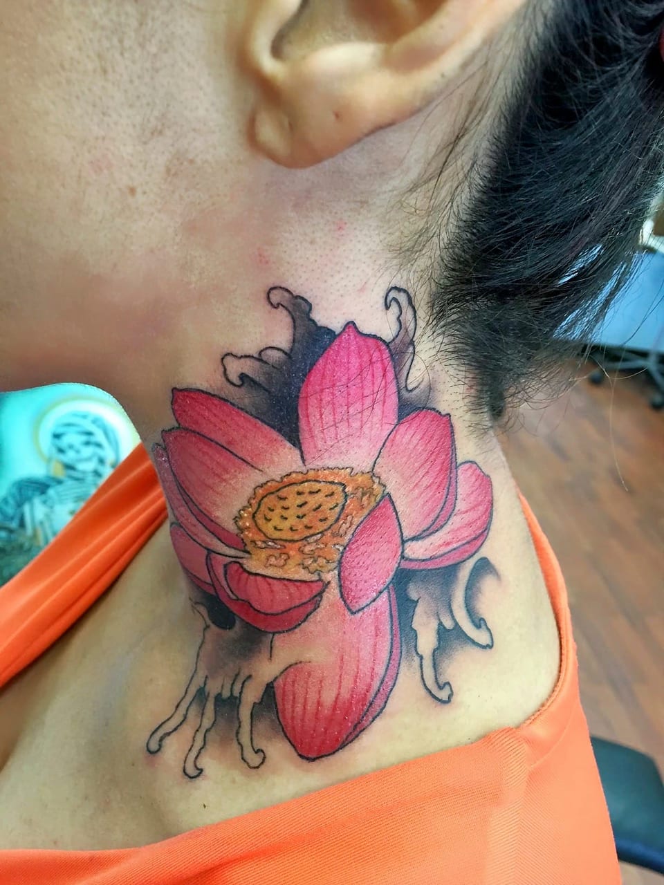 A color Japanese pink lotus and dark waves cover the side of a neck.