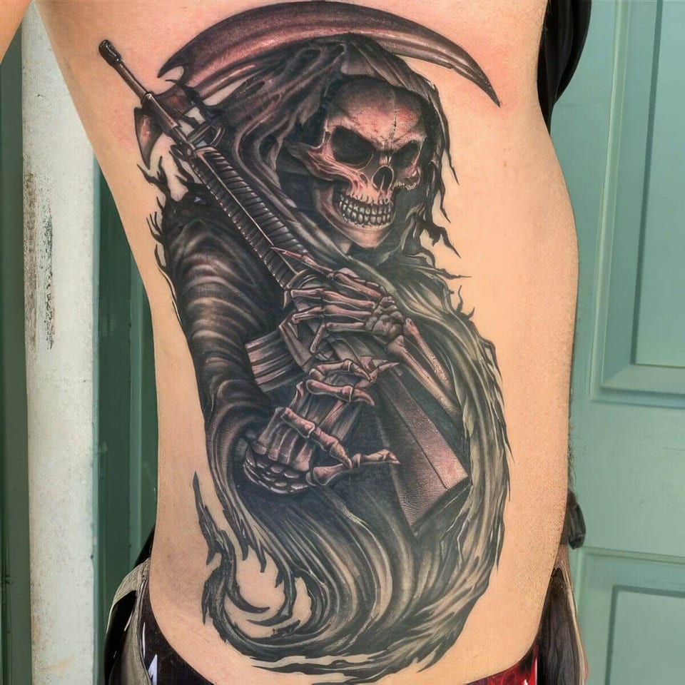 A black-and-grey grim reaper with a rifle and scythe covers the ribs.