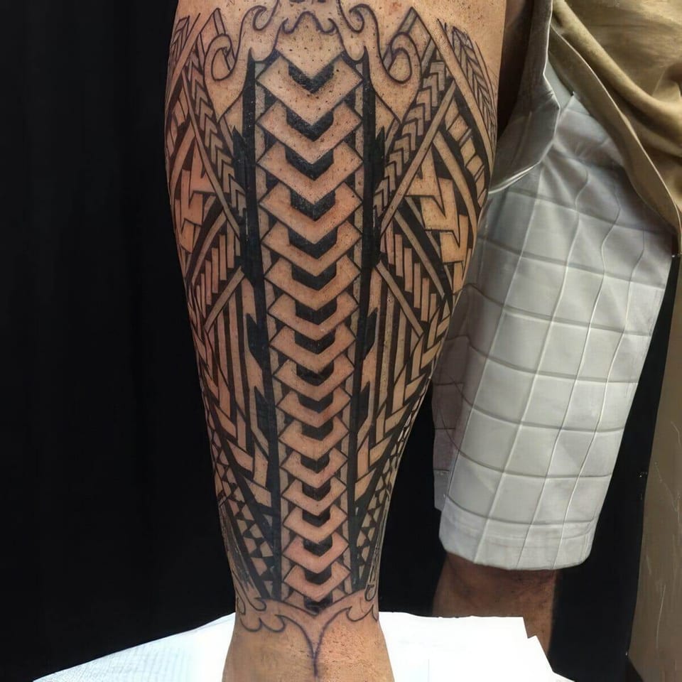 Black Polynesian-style geometric chevron pattern tattooed down a calf, tattooed by Seth Reynolds