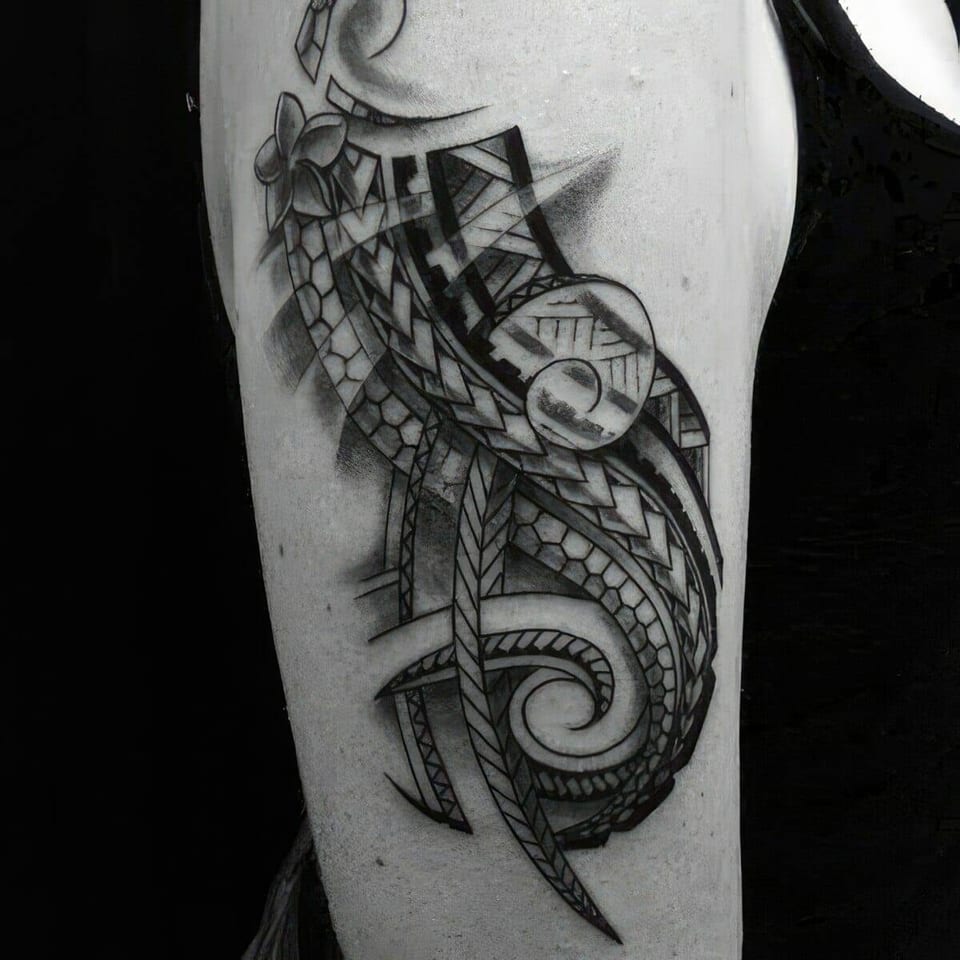 Black and grey abstract tribal pattern with curling lines tattooed on an upper arm, tattooed by Seth Reynolds