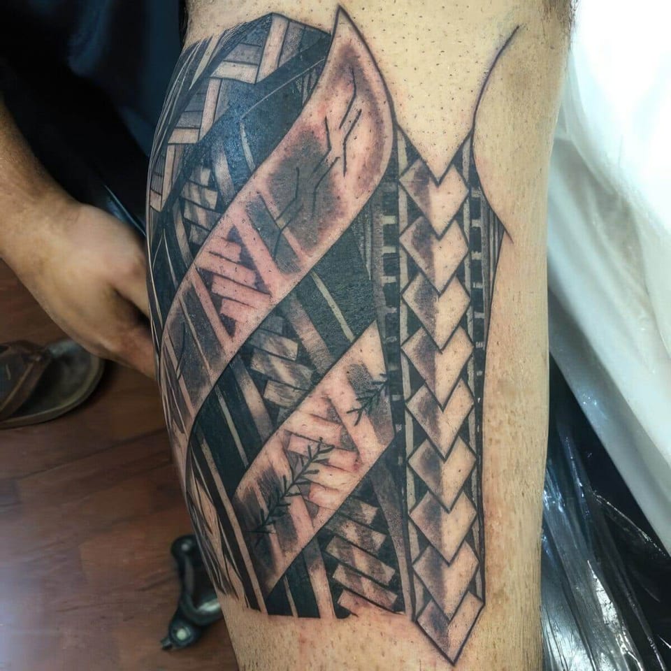 Black and grey Polynesian-style tribal bands with woven patterns tattooed on an upper arm, tattooed by Seth Reynolds