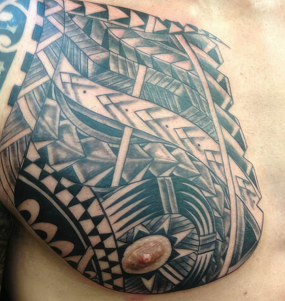 Black Polynesian-style tribal pattern covering a chest and shoulder, tattooed by Seth Reynolds