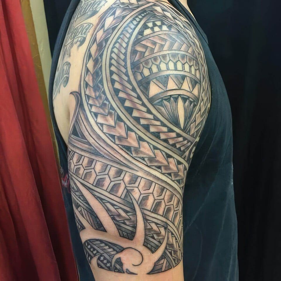 Black Polynesian-style tribal pattern covering a shoulder and upper arm, tattooed by Seth Reynolds