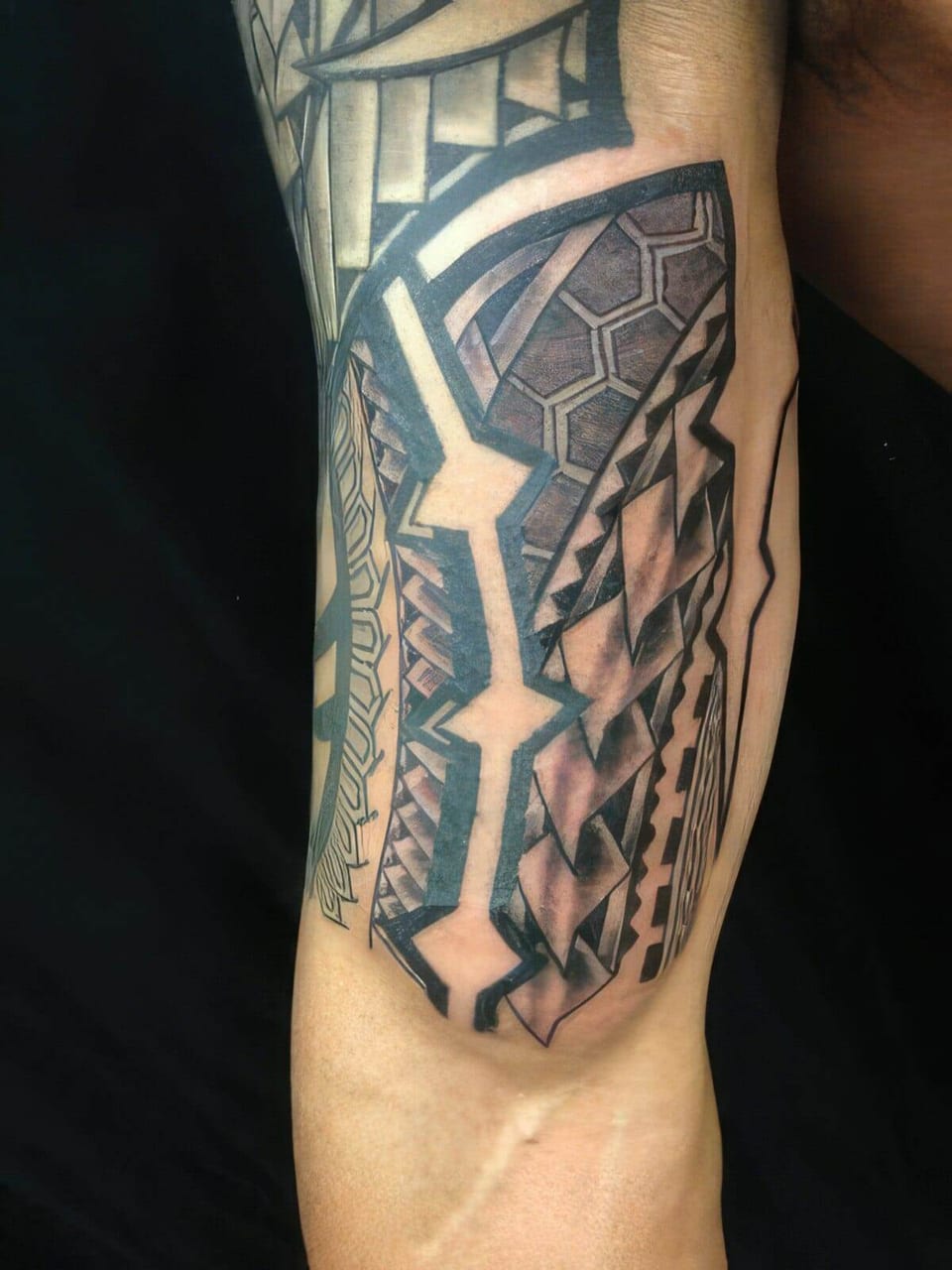 Close-up of black Polynesian-style geometric panels tattooed on an upper arm, tattooed by Seth Reynolds