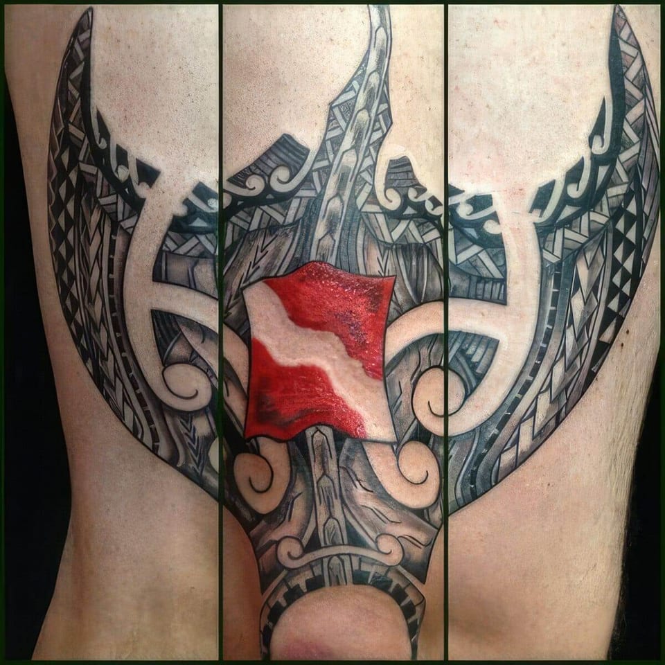 Black Polynesian-style tribal wings with a red dive flag tattooed on an upper arm, shown in three views, tattooed by Seth Reynolds