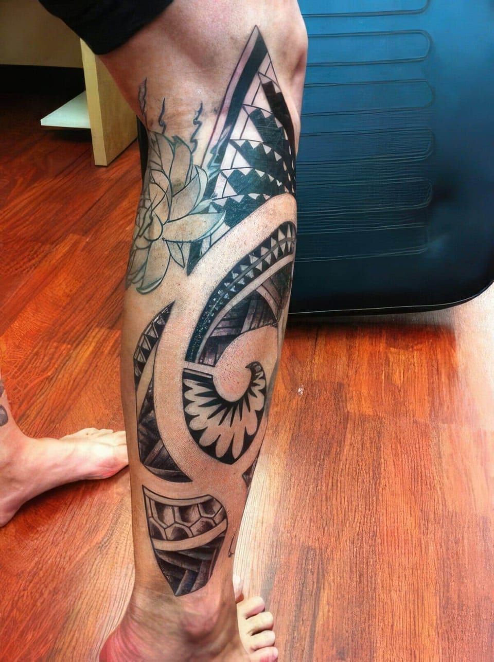 Black Polynesian-style spiral pattern tattooed down a calf, tattooed by Seth Reynolds