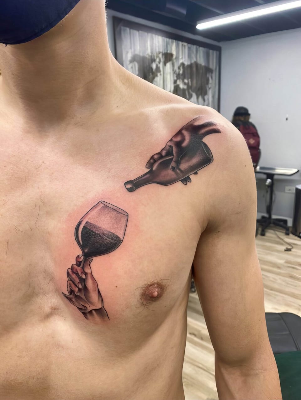 Black and grey illustrative hands hold a tilted bottle and a wine glass across the chest.