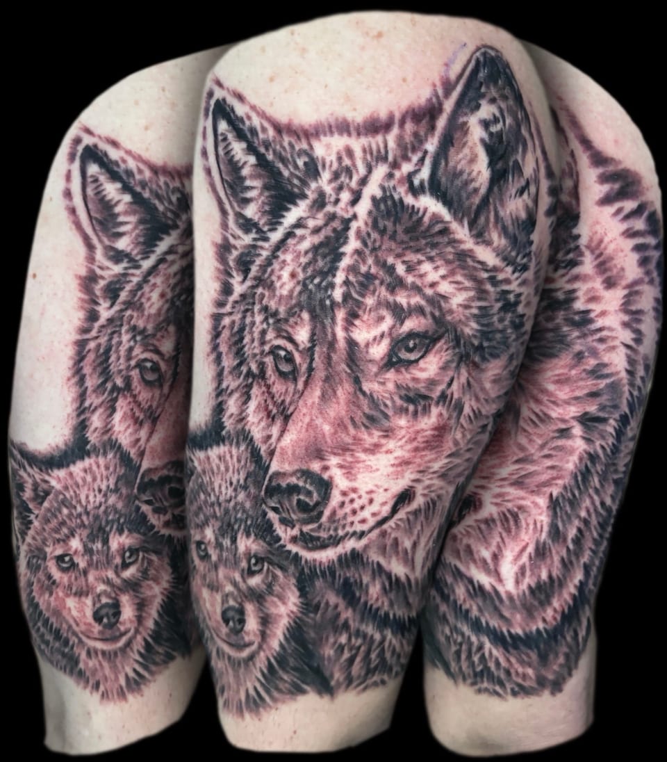 Multiple views show black and grey realistic wolf faces across a shoulder and upper arm.