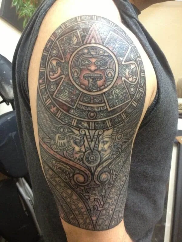 A man with a traditional Aztec tattoo on his arm.