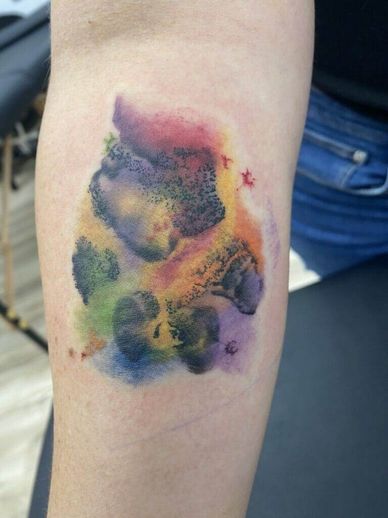 A woman's arm with a colorful tattoo on it.