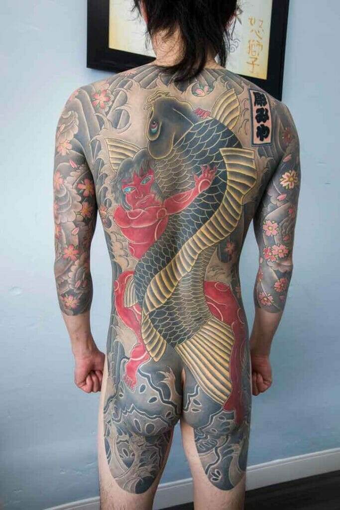 The back of a man with a koi fish tattoo.