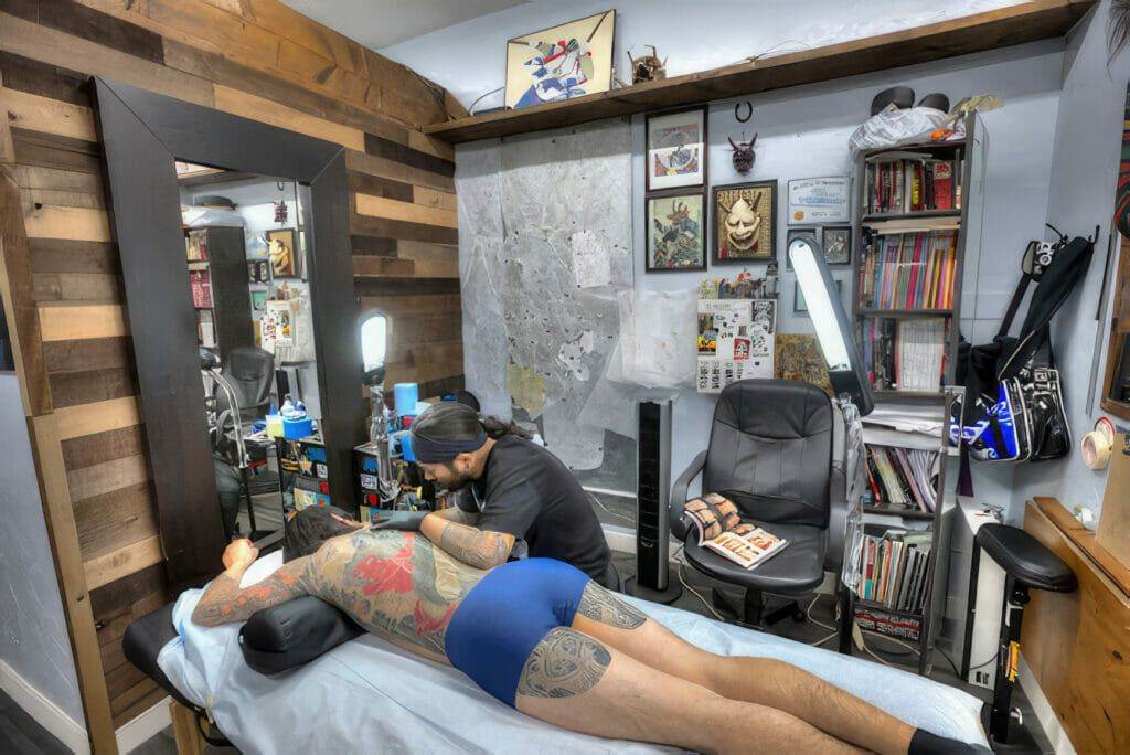 A man is getting a tattoo at Funhouse, a tattoo shop in San Diego.