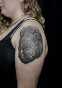 A woman with a lion tattoo on her shoulder.
