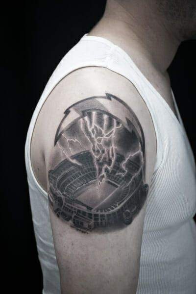 A man with a tattoo of a stadium and lightning.