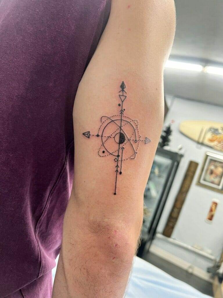 A man with a compass tattoo on his arm.