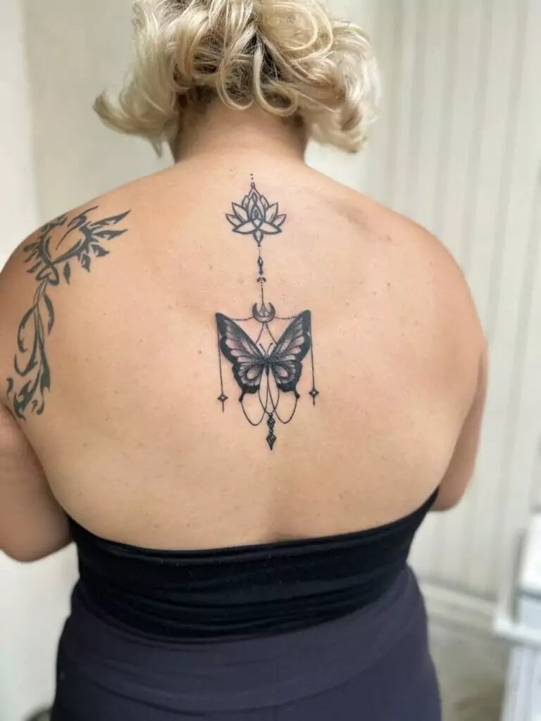 A woman with a butterfly tattoo on her back.