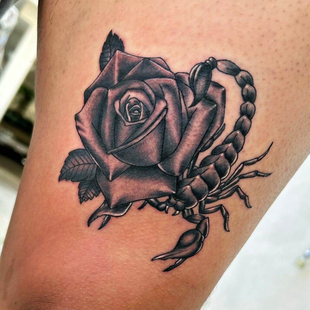 A tattoo of a scorpion and rose on the thigh.