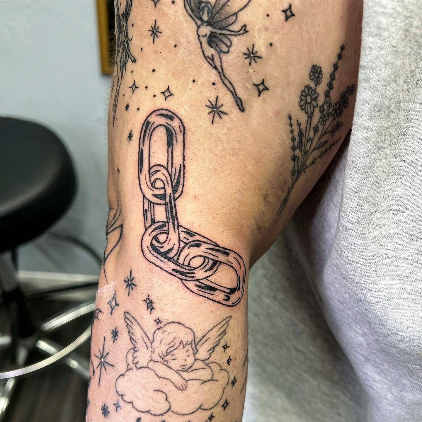 A man with a tattoo of a chain on his arm.