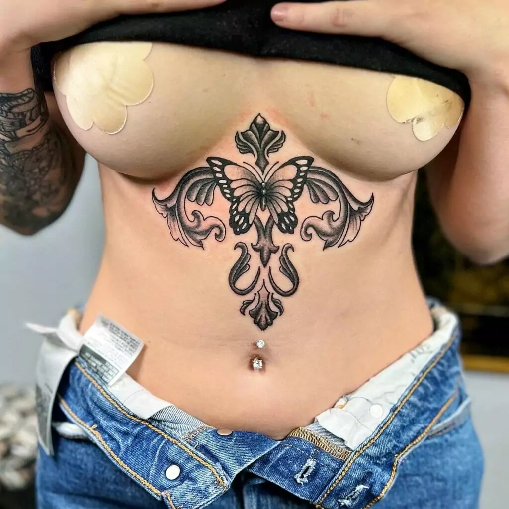 A woman with a butterfly tattoo on her stomach.