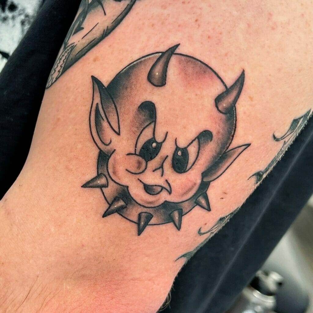 A tattoo of a devil with spikes on his arm.