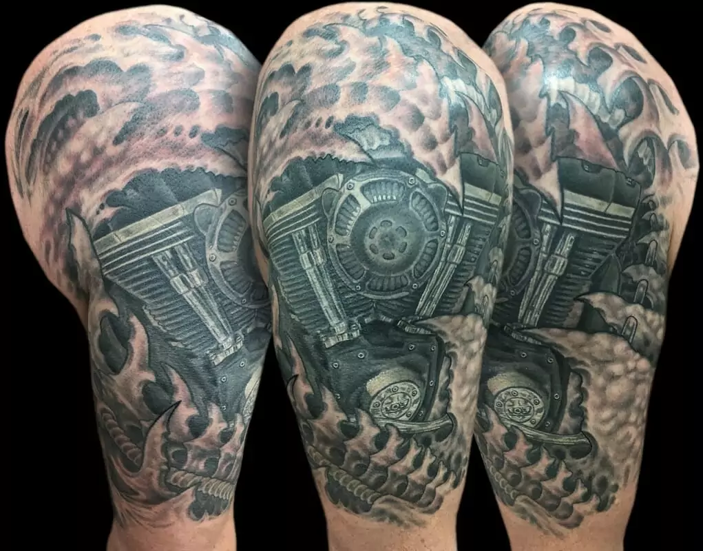 A tattoo of a motorcycle with a skull on it.