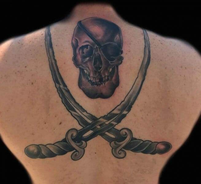 A man with a skull and two swords tattooed on his back.