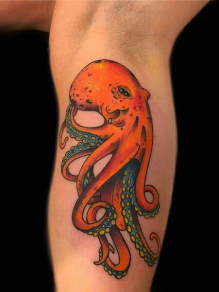 An orange octopus tattoo on the thigh.