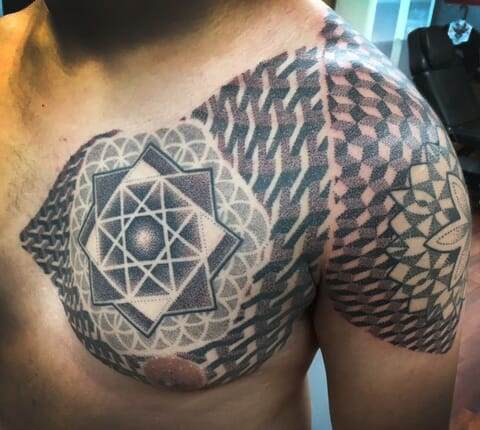 A man with a geometric tattoo on his chest.