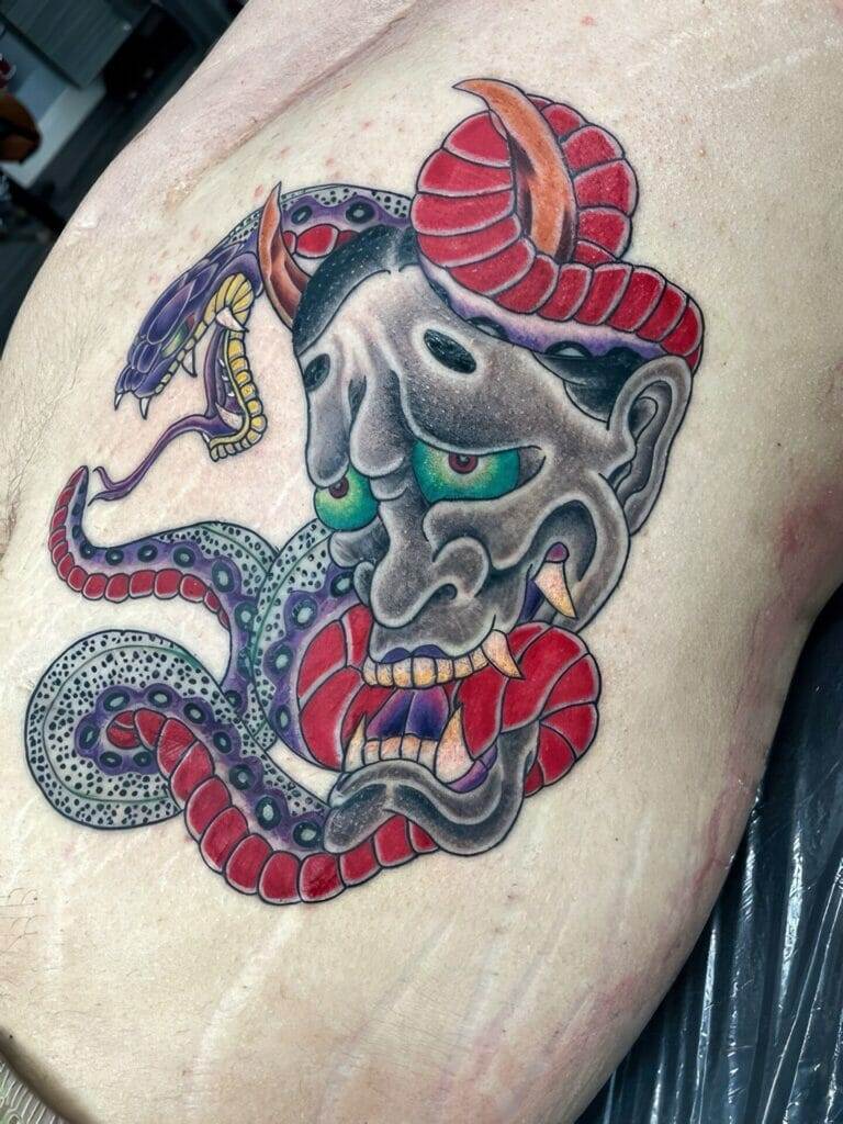 Japanese demon tattoo on a man's stomach.