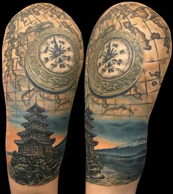 A sleeve tattoo with a map and compass.