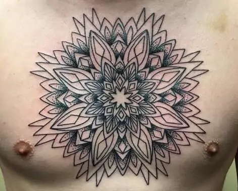 A man's chest with a mandala tattoo.