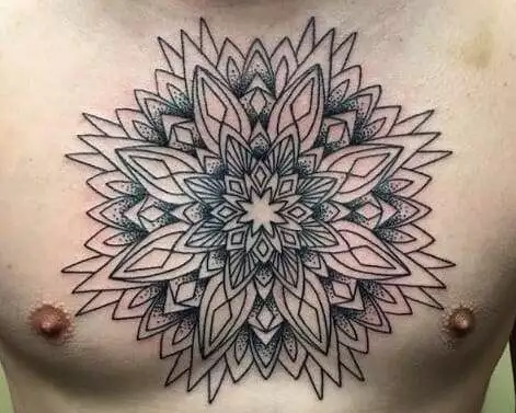 A man's chest with a mandala tattoo.