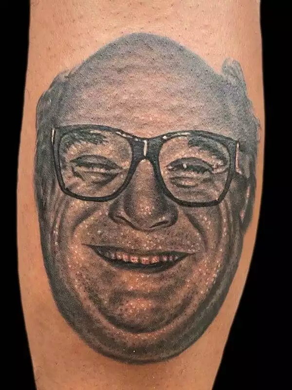 A tattoo of a man with glasses on his leg.