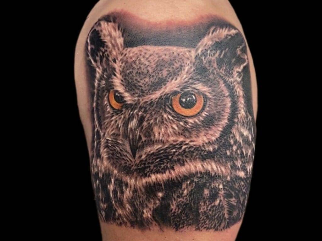 An owl tattoo on a man's arm.