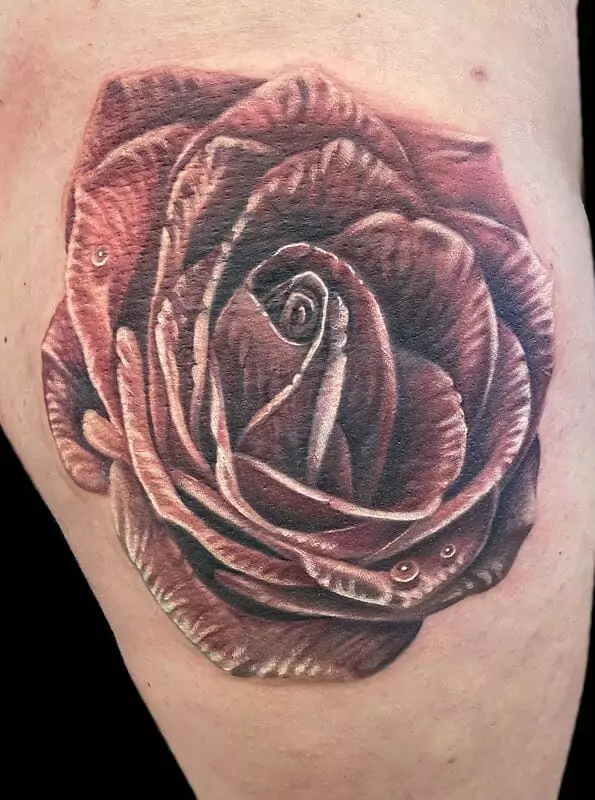 A rose tattoo on a woman's thigh.
