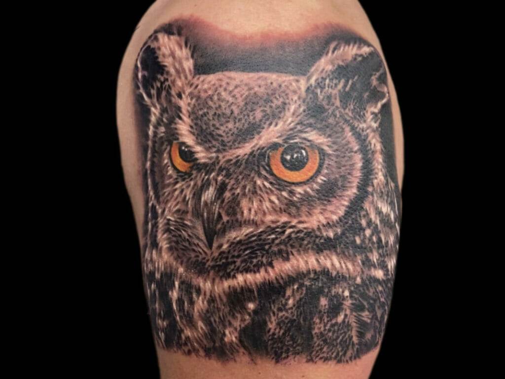 An owl tattoo on a man's arm.