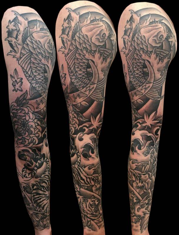 A black and grey tattoo of a koi fish on the sleeve.