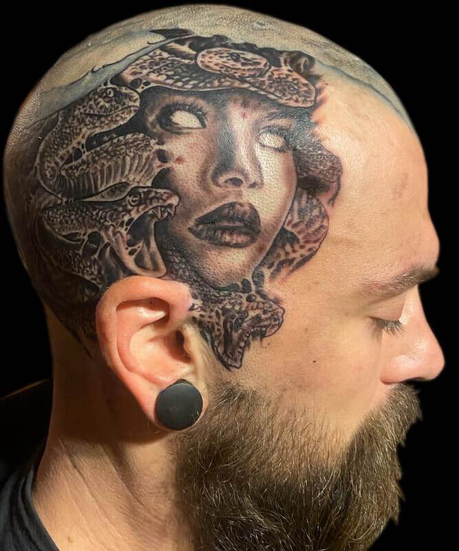 A man with a tattoo of a woman with snakes on his head.