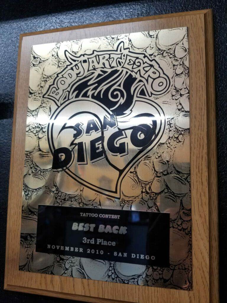 A plaque displaying "San Diego" adorned with intricate tattoos.