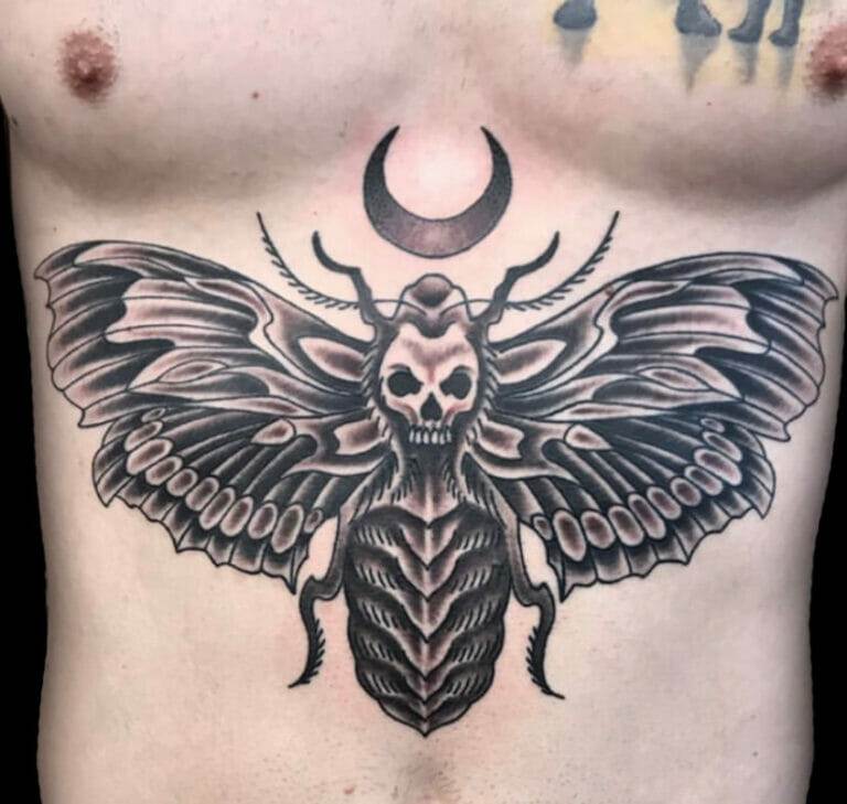 A tattoo of a moth on a man's chest.